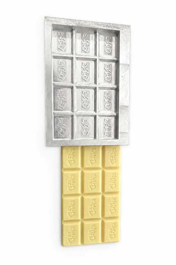 Fertiges Teststück aus weißer Schokolade neben einem Prototyp einer kundenspezifischen Schokoladenform