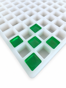 Close-up of a 2.625mL square gummy mold with 266 cavities showing translucent emerald green square gummies seated in the mold on a clean white background