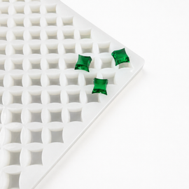 Close-up of a 2mL star gummy mold with 192 cavities and emerald green gummies on a white background