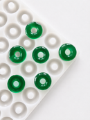 Angled view of the 3.4mL peach ring gummy mold with 108 cavities and translucent emerald green peach ring gummies