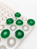 3.4mL peach ring gummy mold with 108 cavities and emerald green peach ring gummies on a white background