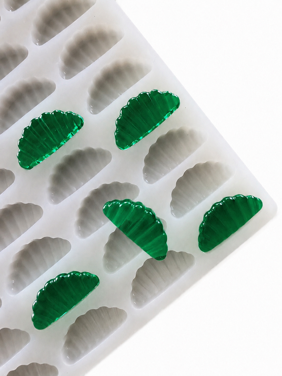3mL orange slice gummy mold with 140 cavities and translucent emerald green gummy samples on a white background